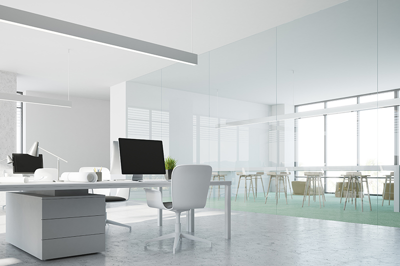 Interior of a modern office with a concrete and green floor, panoramic windows and black computer screens on the tables. 3d rendering mock up