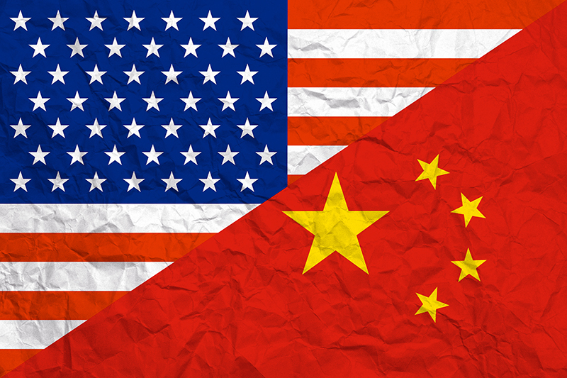 Concept image: relationship USA - China. USA and China flags diagonal portions on crumpled paper backdrop.
