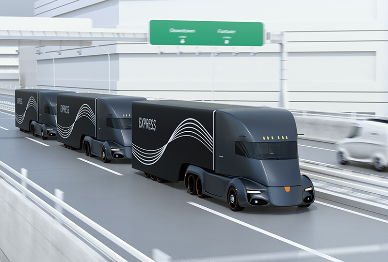 A fleet of black self-driving electric semi trucks driving on highway. 3D rendering image.