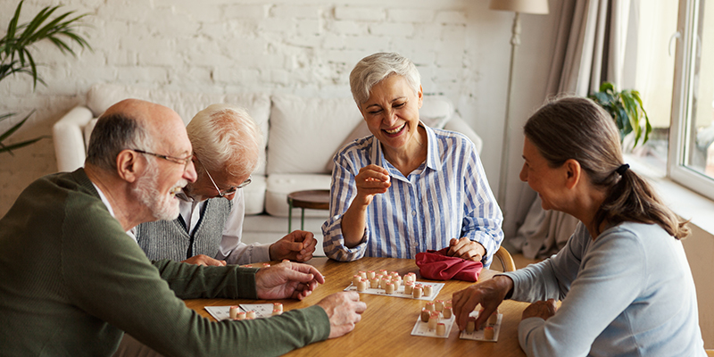 Four seniors playing a game in a senior living community