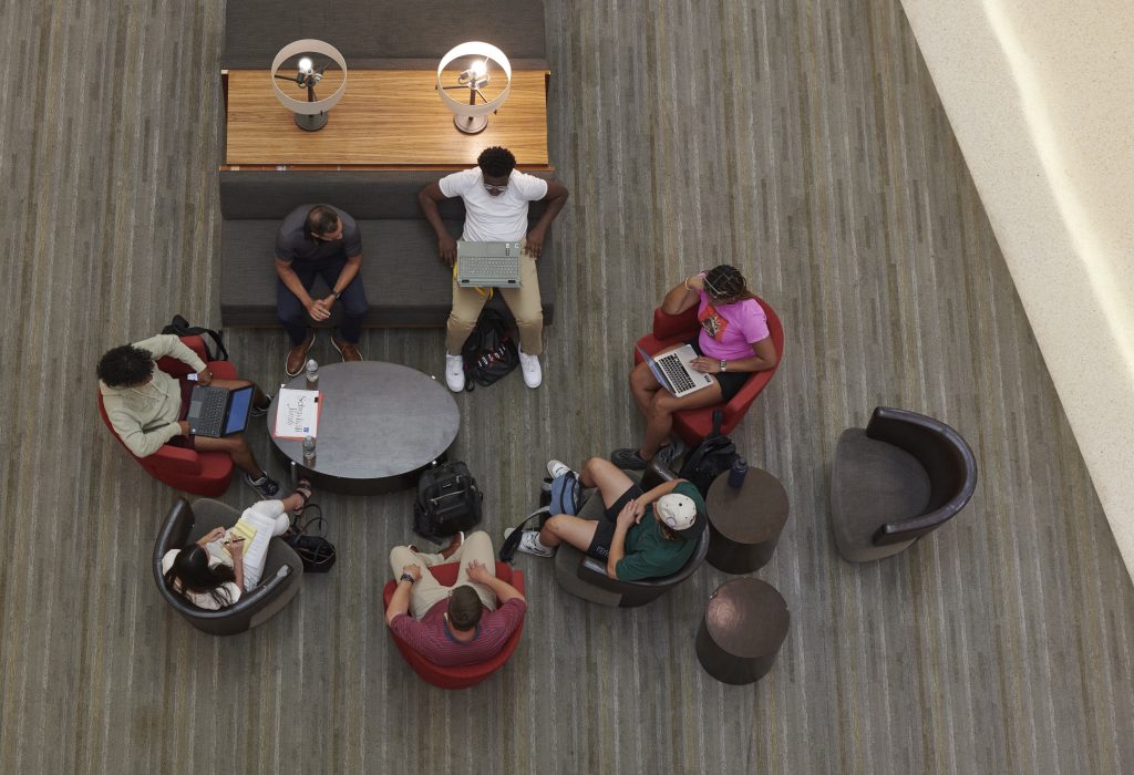 A group of students assembles with their mentors to plan for the final Case Competition. 